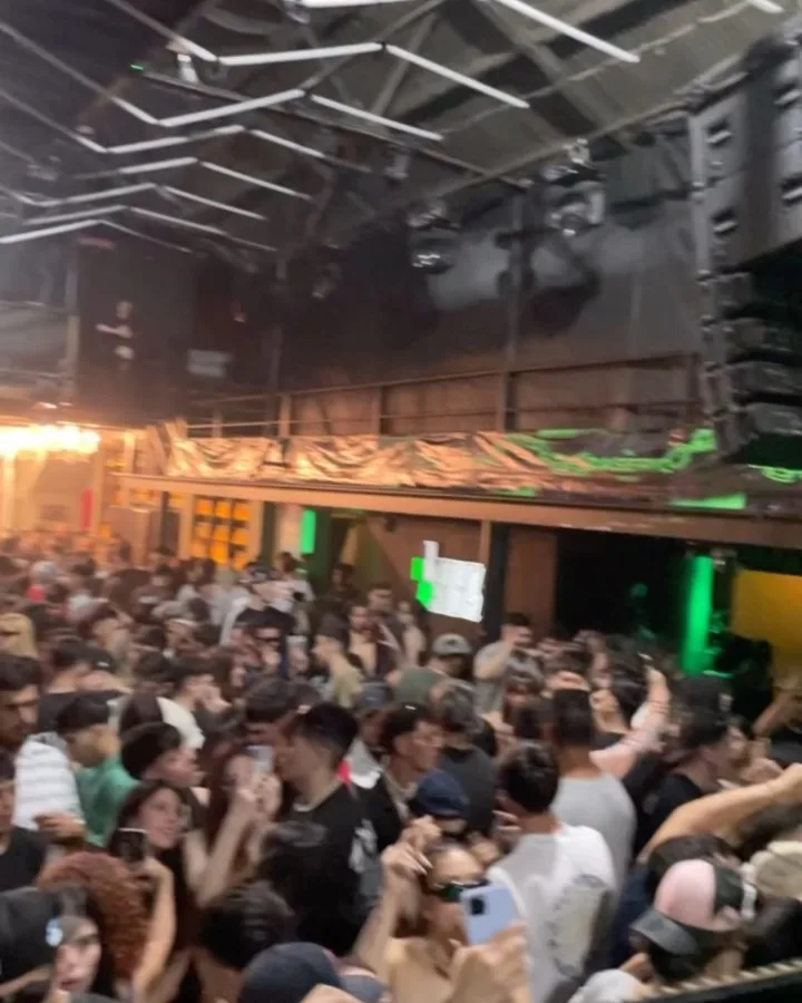 Pista abarrotada con público y luces verdes de festival